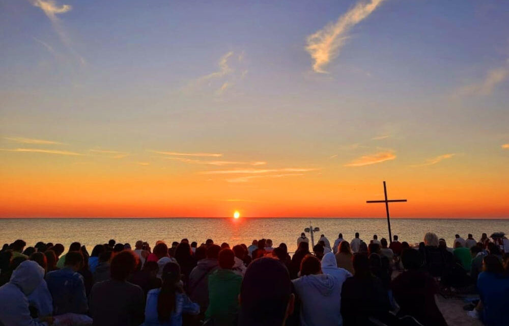 Una folla di giovani in riva al mare con il vescovo Palmieri