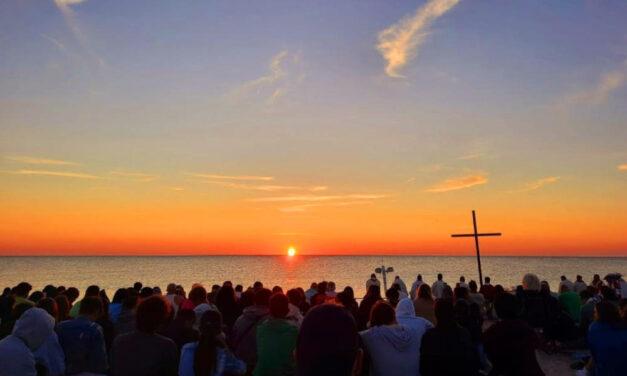 Una folla di giovani in riva al mare con il vescovo Palmieri